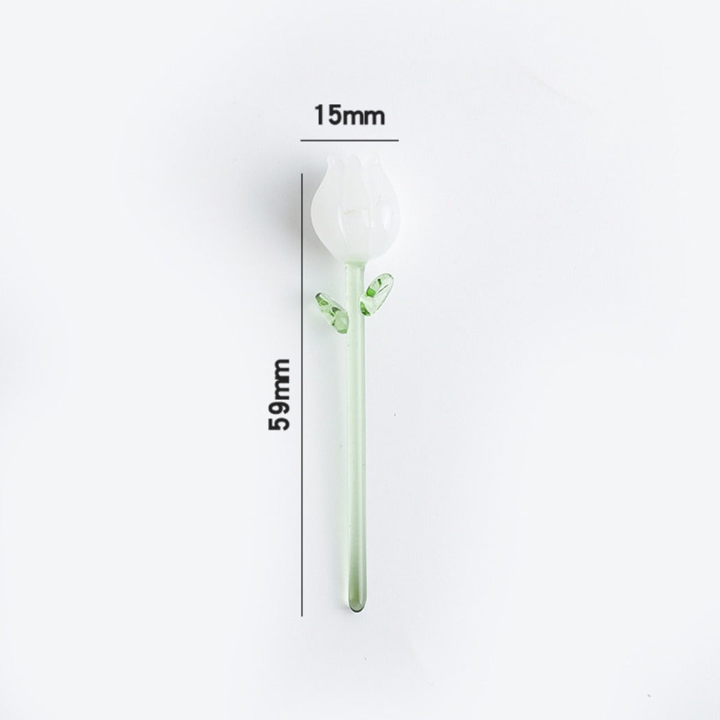 Mini glass rose with vibrant pink petals and translucent green leaves on a plain surface