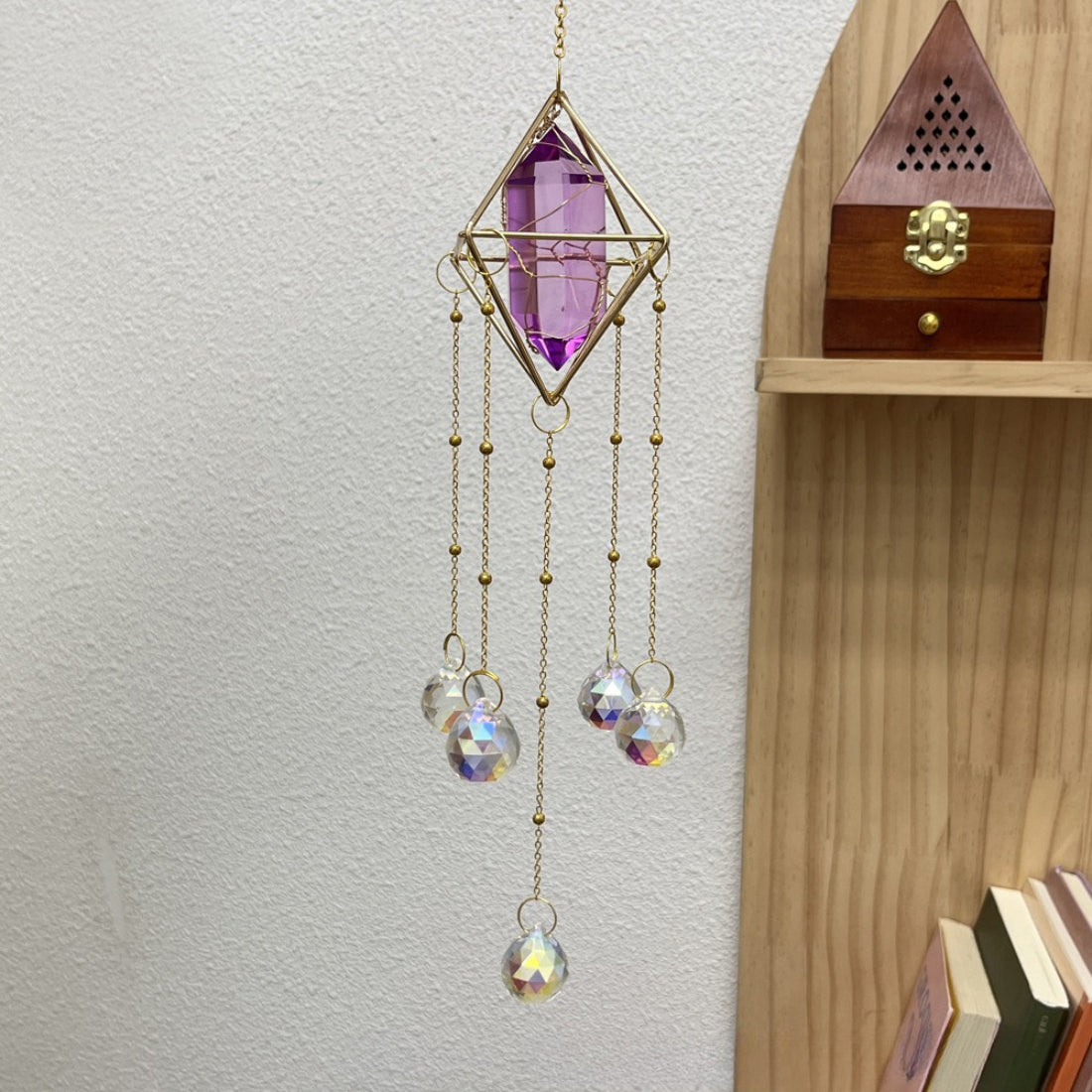Somnira geometric prism suncatcher hanging indoors near a window with sunlight